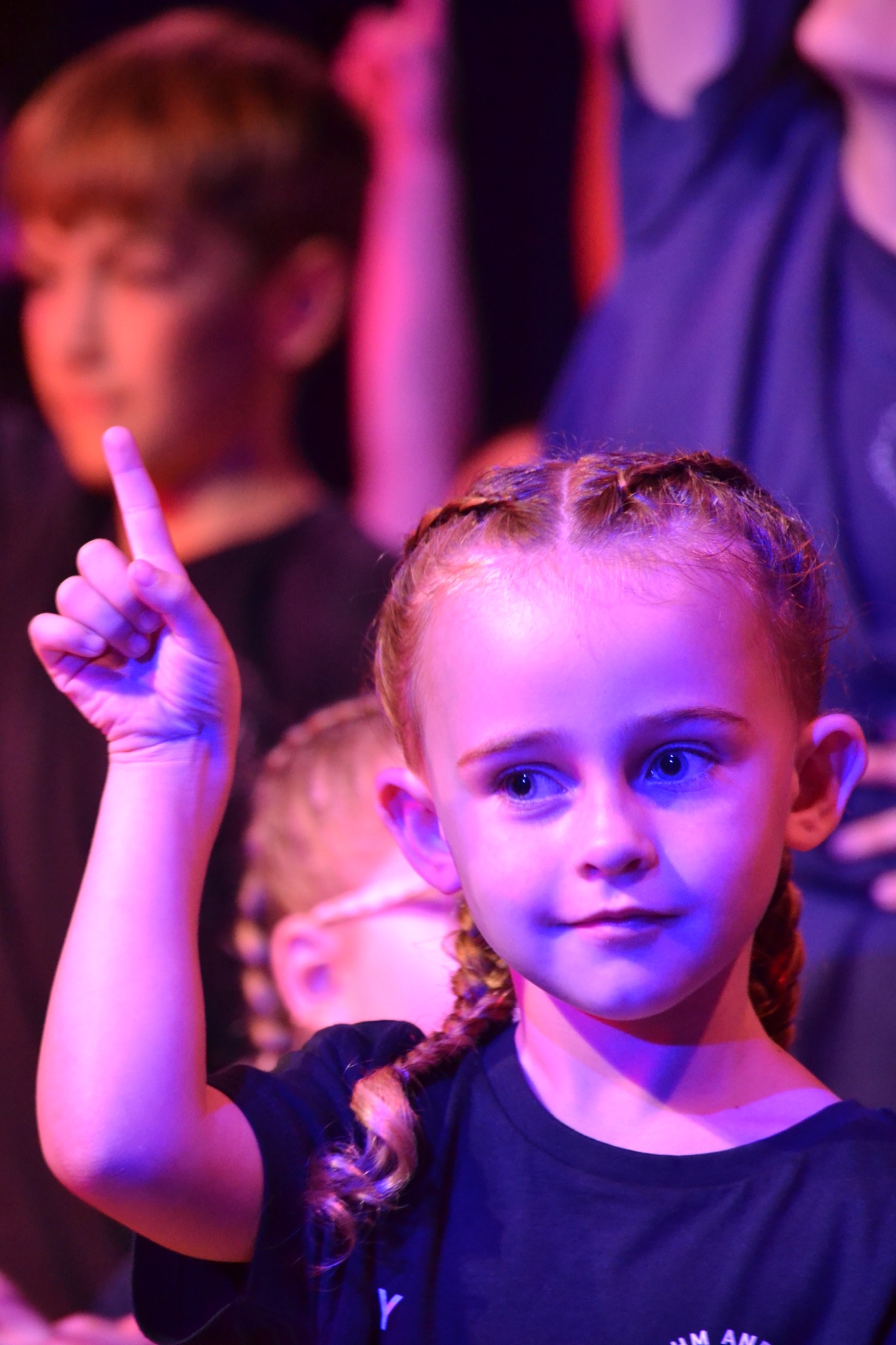 A performer raises one finger during a group routine.